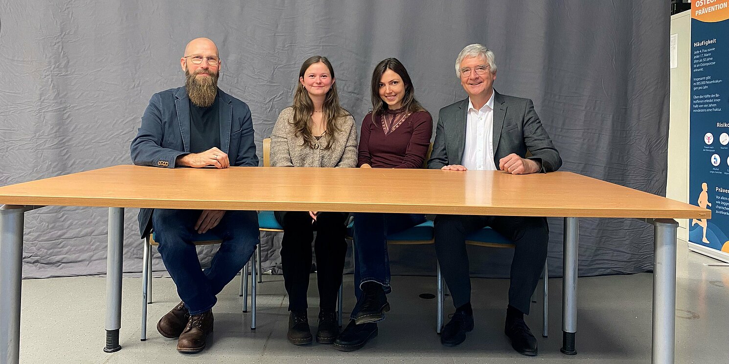 Vier Personen sitzen an einem Tisch