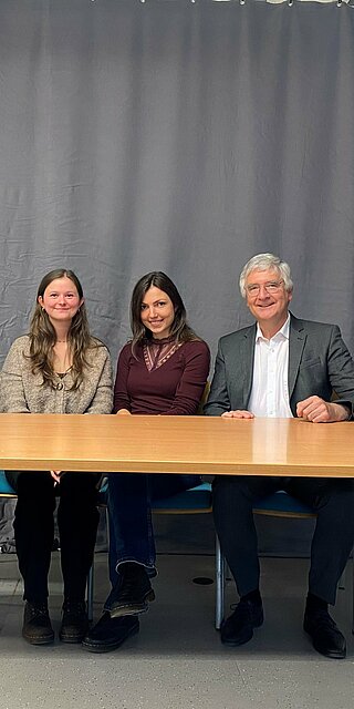 Vier Personen sitzen an einem Tisch