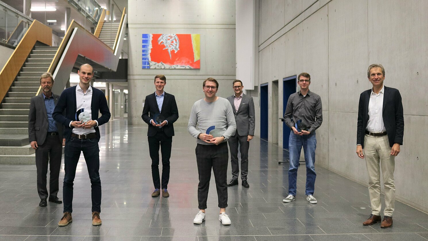 Prof. Dr. Wolfgang Baier, Prof. Dr. Oliver Steffens und Eduard B. Wagner mit einem Teil der Preisträger. Die weiteren Preisträgerinnen waren per Zoom zugeschaltet. Prof. Dr. Wolfgang Baier, Präsident der OTH Regensburg (links), Prof. Dr. Oliver Steffens, Vizepräsident der OTH Regensburg (5.v.l.), und Eduard B. Wagner, Vorsitzender des Vereins der Freunde (rechts), mit den Preisträgern (v.l.) Johannes Koller, Jonas Sassenhausen, Maximilian Weiherer und Dominik Kemeter. Die Preisträgerinnen Sibel Erhan, Morgane Anne Müller und Inga Ehrenberg waren per Zoom zugeschaltet.